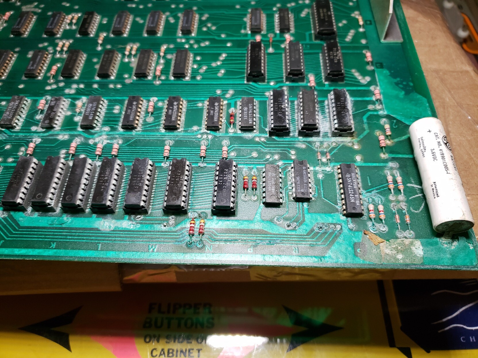 An arcade game PC board with visible corrosion from the still in-place leaking battery