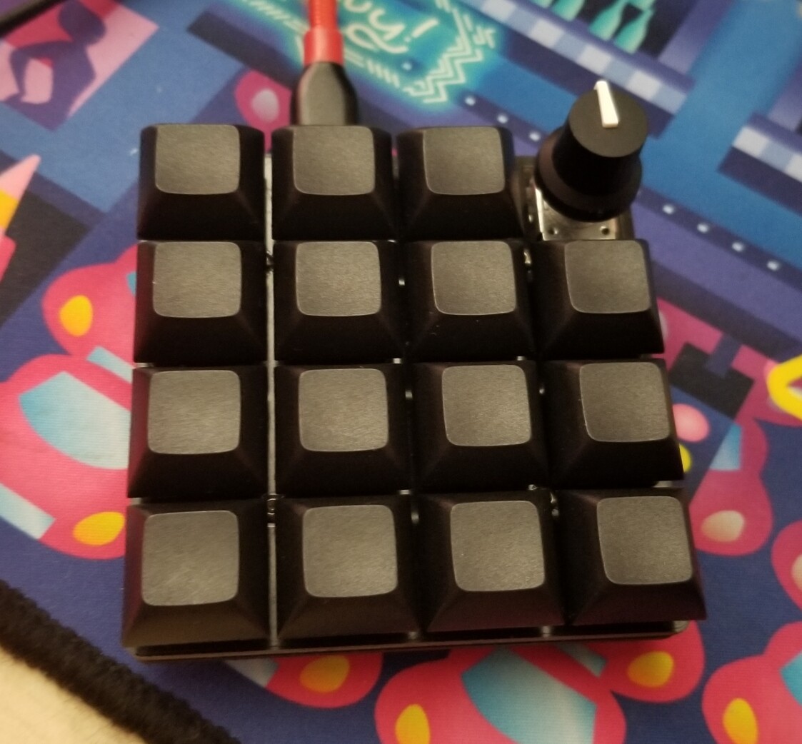The top of the macropad, with 15 keys and a rotary encoder.